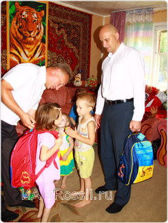 Зам. председателя горсовета Виктор Корхов (слева) и глава города Николай Патов вручают детям подарки, собранные в рамках акции 